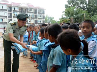 图为官兵向孩子们发放衣服.JPG